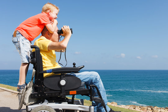Disabled father and son play with Binocular