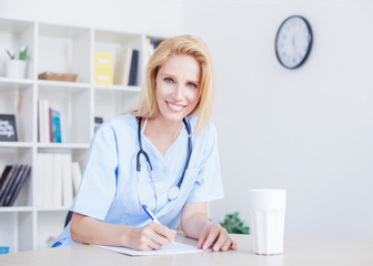 Young female doctor and practitioner working at desk