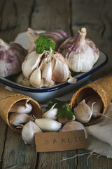 Purple garlics on a napkin on a wooden rustic table