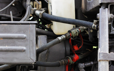 hoses, engine and spare parts inside the hood of the tractor