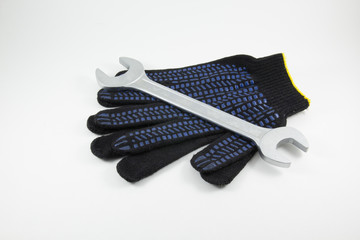 Wrench and work gloves on a white background