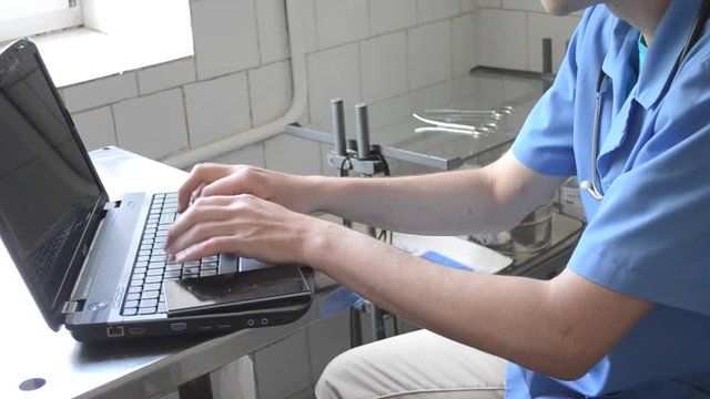 doctor typing on laptop
