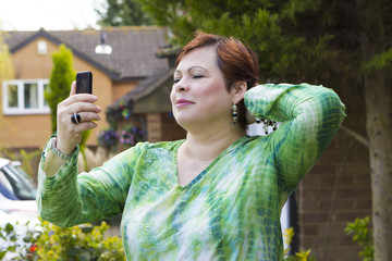 Fototapeta premium Cheerful woman doing selfie outdoors