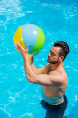 Mann spiel im Pool mit einem Wasserball