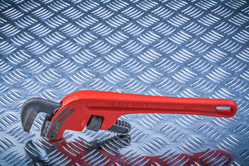 Metal pipe wrench on corrugated metallic plate maintenance conce