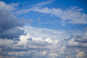 Sky clouds, blue fluffy storm clouds. Background of blue sky with white cumulus clouds.