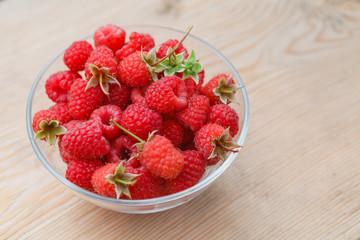 Ripe raspberries in glass bowl. Close-up.
