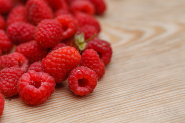 Ripe sweet raspberries on wooden background