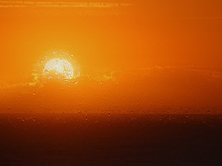 rain drops on a window in front of a beautiful sunrise 