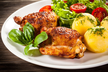 Barbecued chicken legs with boiled potatoes and vegetables