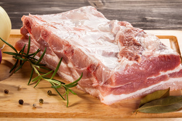Raw pork ribs on cutting board and vegetables 
