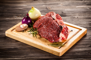 Raw beef on cutting board and vegetables
