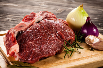 Raw beef on cutting board and vegetables