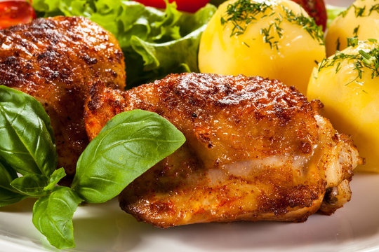 Barbecued chicken legs with boiled potatoes and vegetables