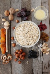 Granola bars ingredients on wood background, top view