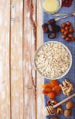 Granola bars ingredients on wood background, top view