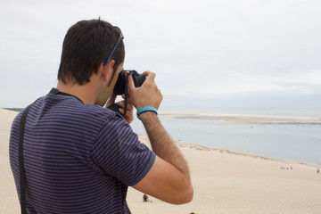 Man taking photos of the sea and the coast of France
