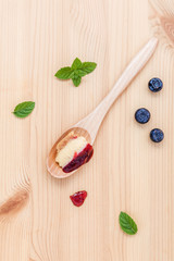 Composition of blueberry cheesecake in wooden spoon with fresh m