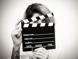 Young blonde woman with movie clapper portrait