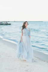 Fototapeta na wymiar Cheerful bride making a walk along the beach