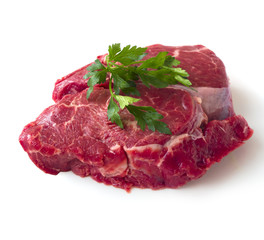 Raw beef fillet steak with sprig of parsley on white background, isolated