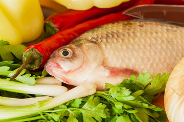 Carp fish with green vegetables, herbs, red chili