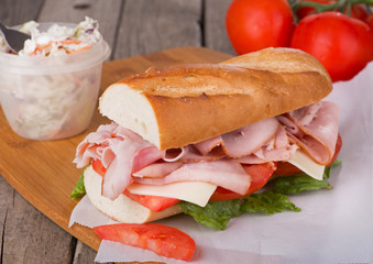 Ham Sub Sandwich With Coleslaw and Tomatoes in Background