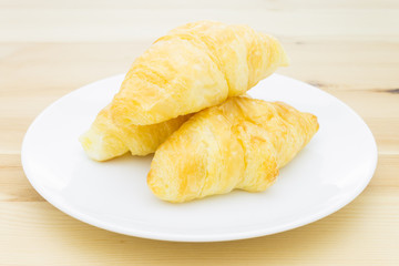 Croissant or Bakery on White Dish on Wood Table