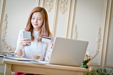 Happy woman shopping online, holding credit card.