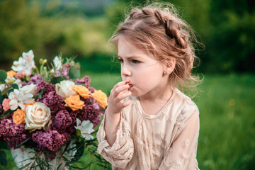 Obraz premium Little baby girl eats chocolate cake in nature at a picnic. The concept of a happy childhood