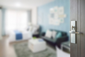 opened wooden door to blue color scheme bedroom with sofa