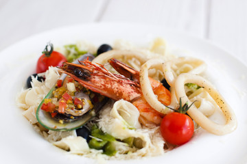Fettuccine pasta with seafood mix on plate closeup. Traditional Italian cuisine meal