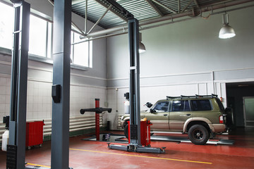 Modern repair shop with SUV on maintenance. Professional car diagnostics in big auto service