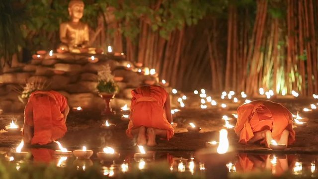 Asalha Puja Day ,Monks light candles and pray to buddha statue, Chiang mai ,Thailand