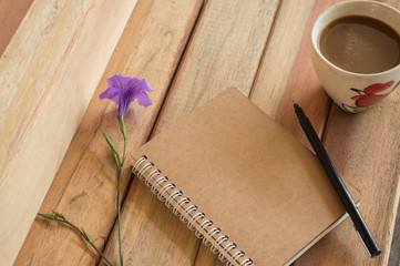 Office wood table with notepad, computer and flower.On top view.

