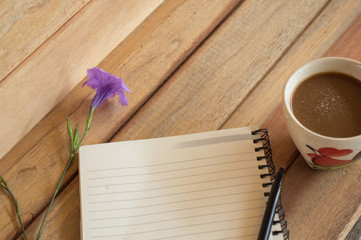 Office wood table with notepad, computer and flower.On top view.

