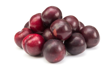 rote Pflaumen liegen auf einem Haufen isoliert auf weißem Hintergrund