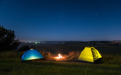 The camping tent stand by picturesque night sky above foggy land background. Wide angle