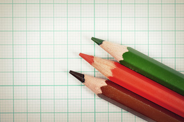 Fototapeta premium Colored pencils with graph plotting paper for background