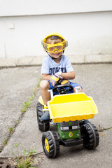 Kleiner Junge auf seinem Spielzeug Traktor