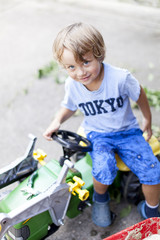 Kleiner Junge auf seinem Spielzeug Traktor