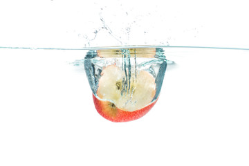 Red apple dropped into the water with water splash on a white ba