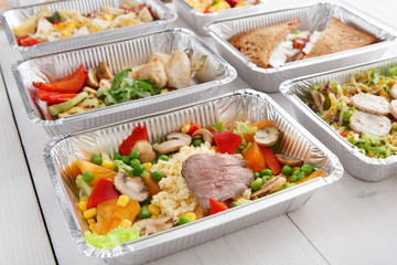Healthy food take away in boxes, top view at wood