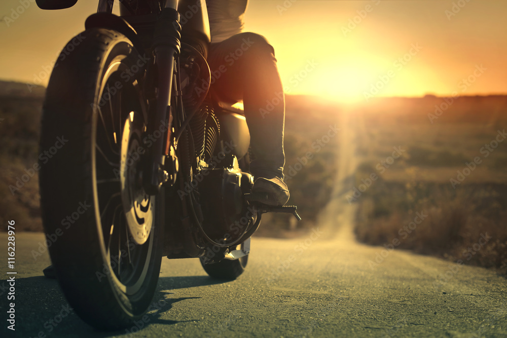 Wall mural On a roaring motorcycle at sunset