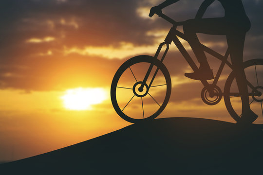 Silhouette of a woman on muontain bike, sunset.Vintage color
