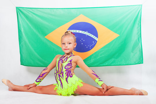 Girl doing artistic gymnastics element, split. Brazilian flag