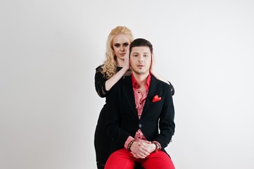 Studio portrait of young stylish beautiful couple. Girl holding hands on face of man