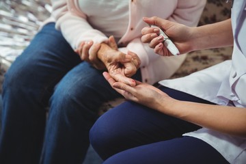 Nurse helping senior woman with diabetes
