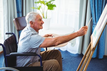 Senior man using brush and easel