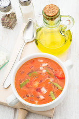 Aerial view of gazpacho soup with oil and spoon in white bowl